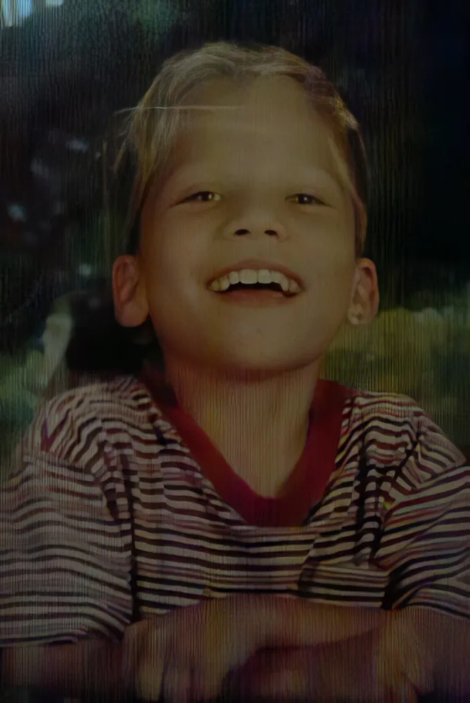 Childhood photo of Jimmy laughing, wearing a striped shirt.